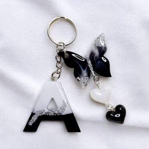 personalized black & white resin initial keychain with butterfly & heart charms